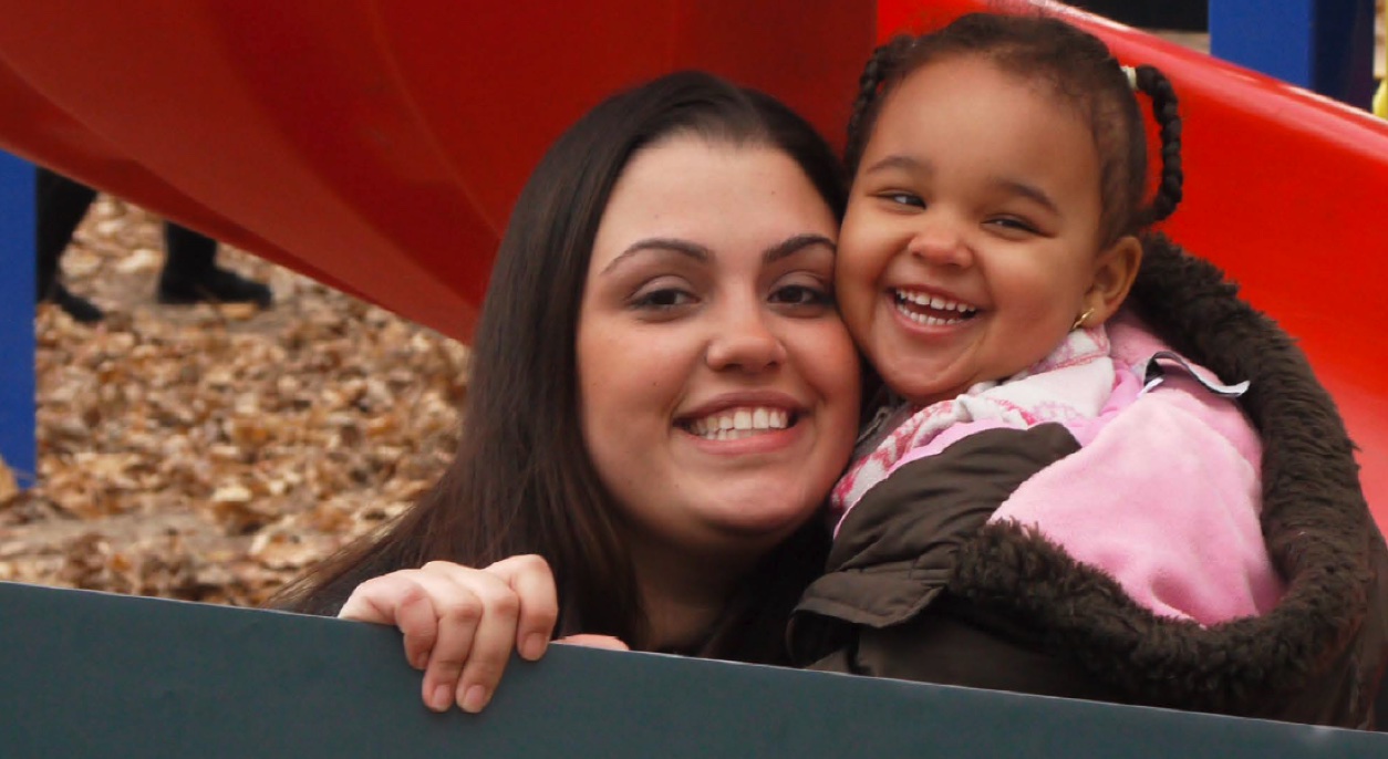 Young mother with daughter smiling at camera
